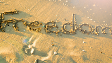 Beach with the word FREEDOM written in the sand