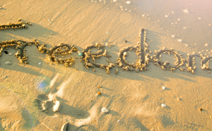Beach with the word FREEDOM written in the sand
